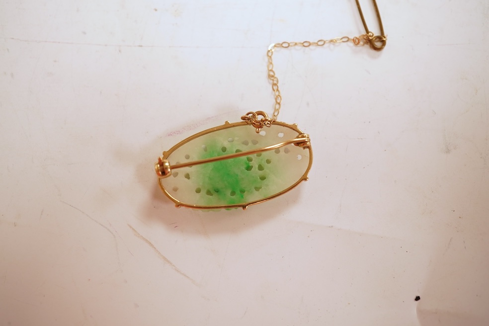 A jadeite brooch, set with an oval jadeite of mottled green and white, carved to depict flowers, mounted in 9ct gold, length 3.2cm, British hallmarks, maker's mark for Cropp & Farr, gross weight approximately 4.5 grams,